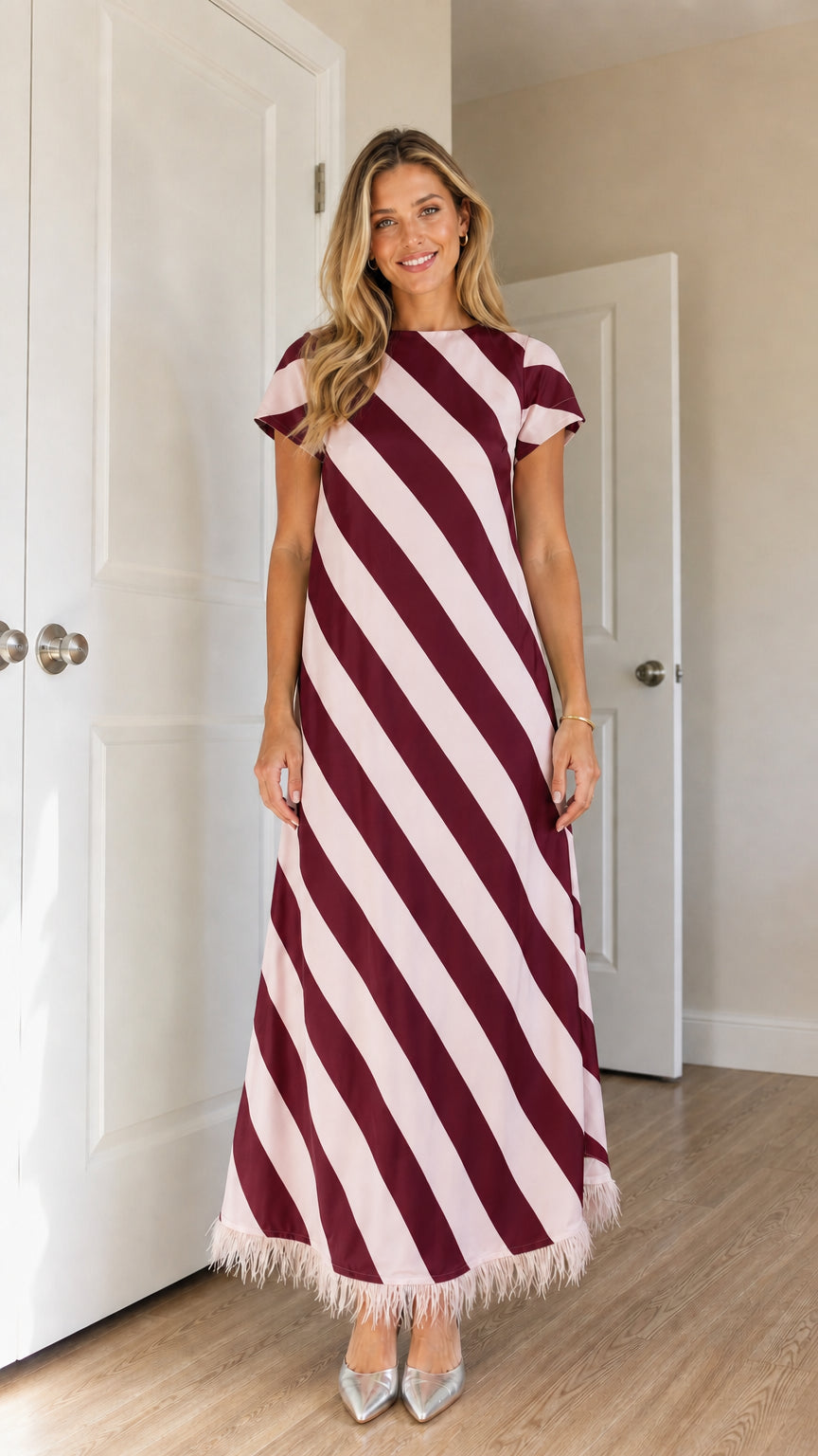 Model wearing burgundy diagonal stripe feather trim maxi dress
