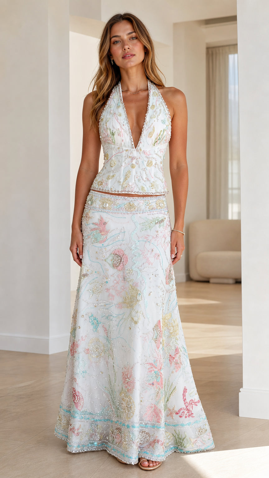 Front view of woman wearing white embroidered halter top and maxi skirt set