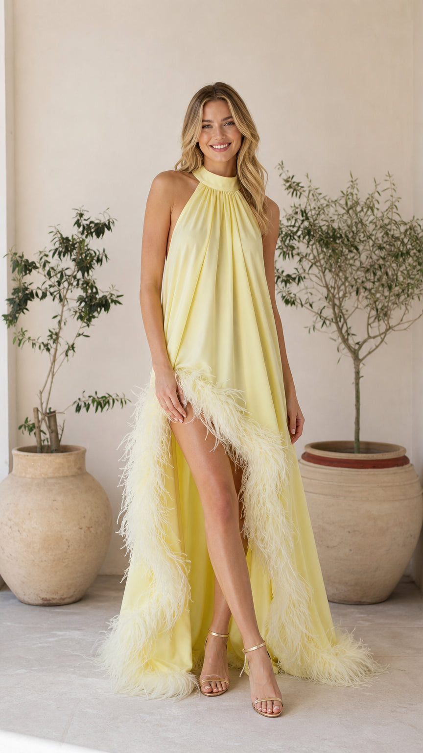 Front view of model wearing yellow feather trim halter maxi dress