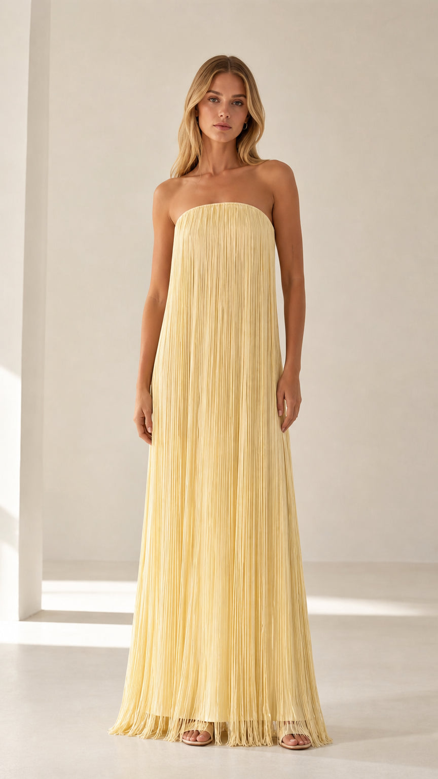 Front view of model wearing yellow strapless pleated fringe maxi dress
