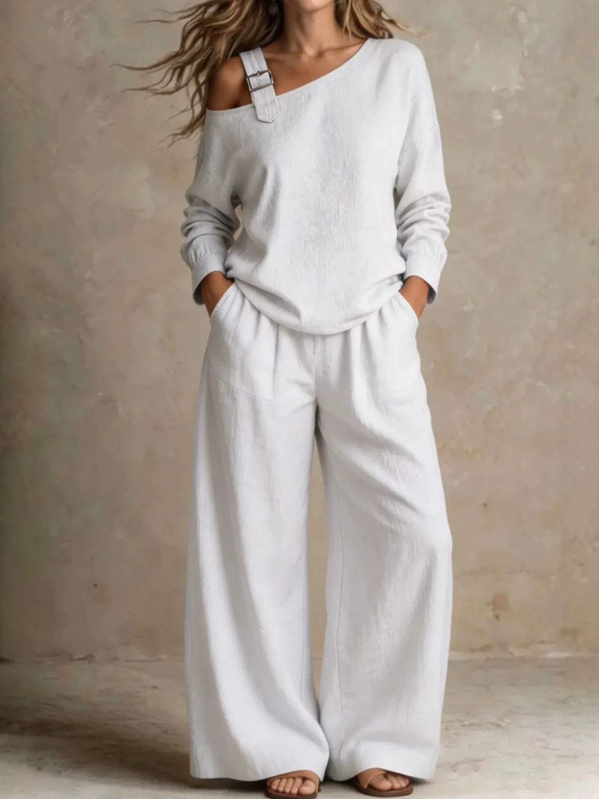 Woman wearing white asymmetric buckle top and wide-leg pants lounge set