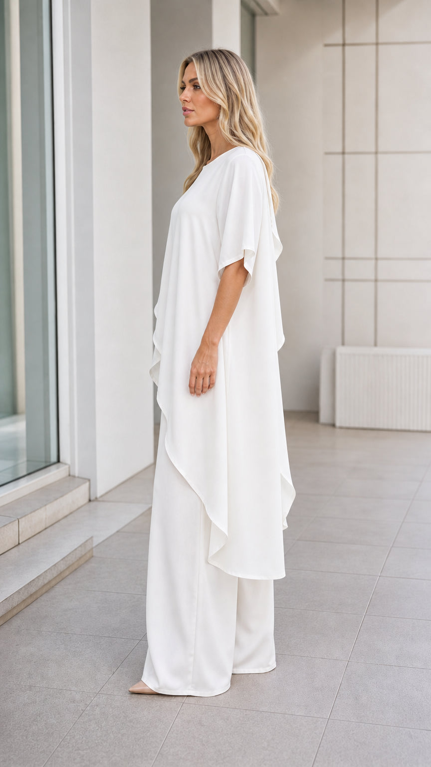 Model wearing white pant set, side profile view