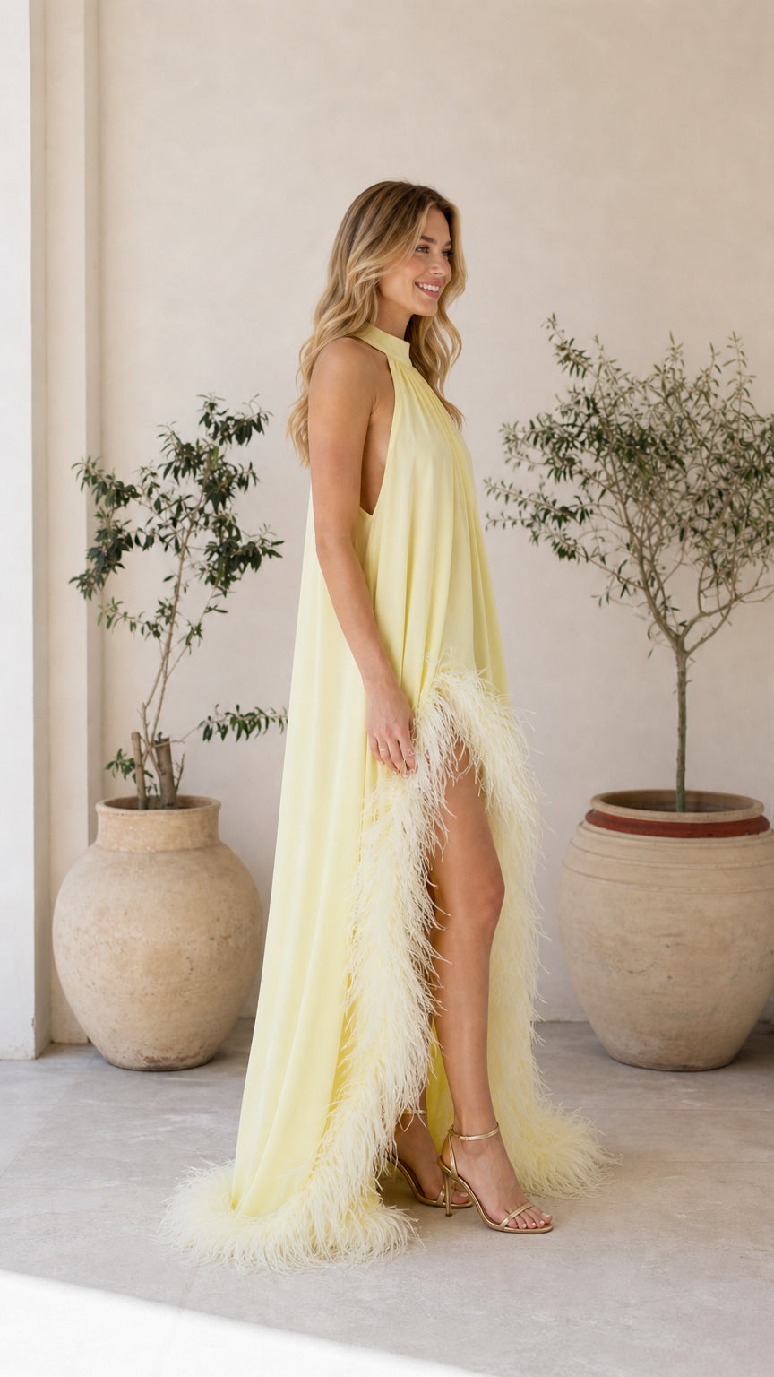 Side profile of model in yellow feather maxi dress