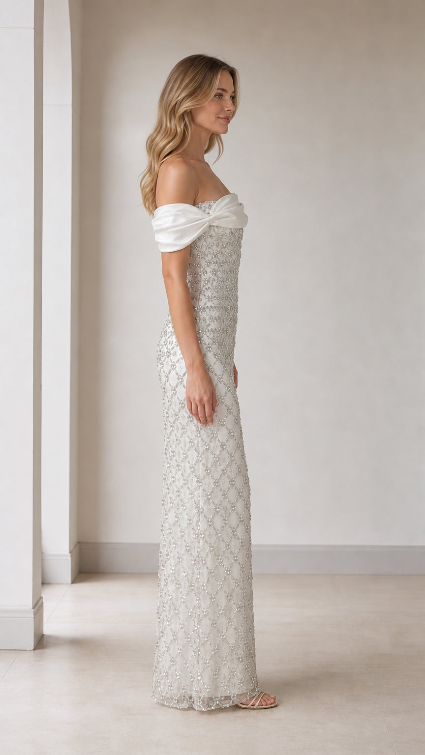 Side profile view of white off-shoulder beaded evening gown