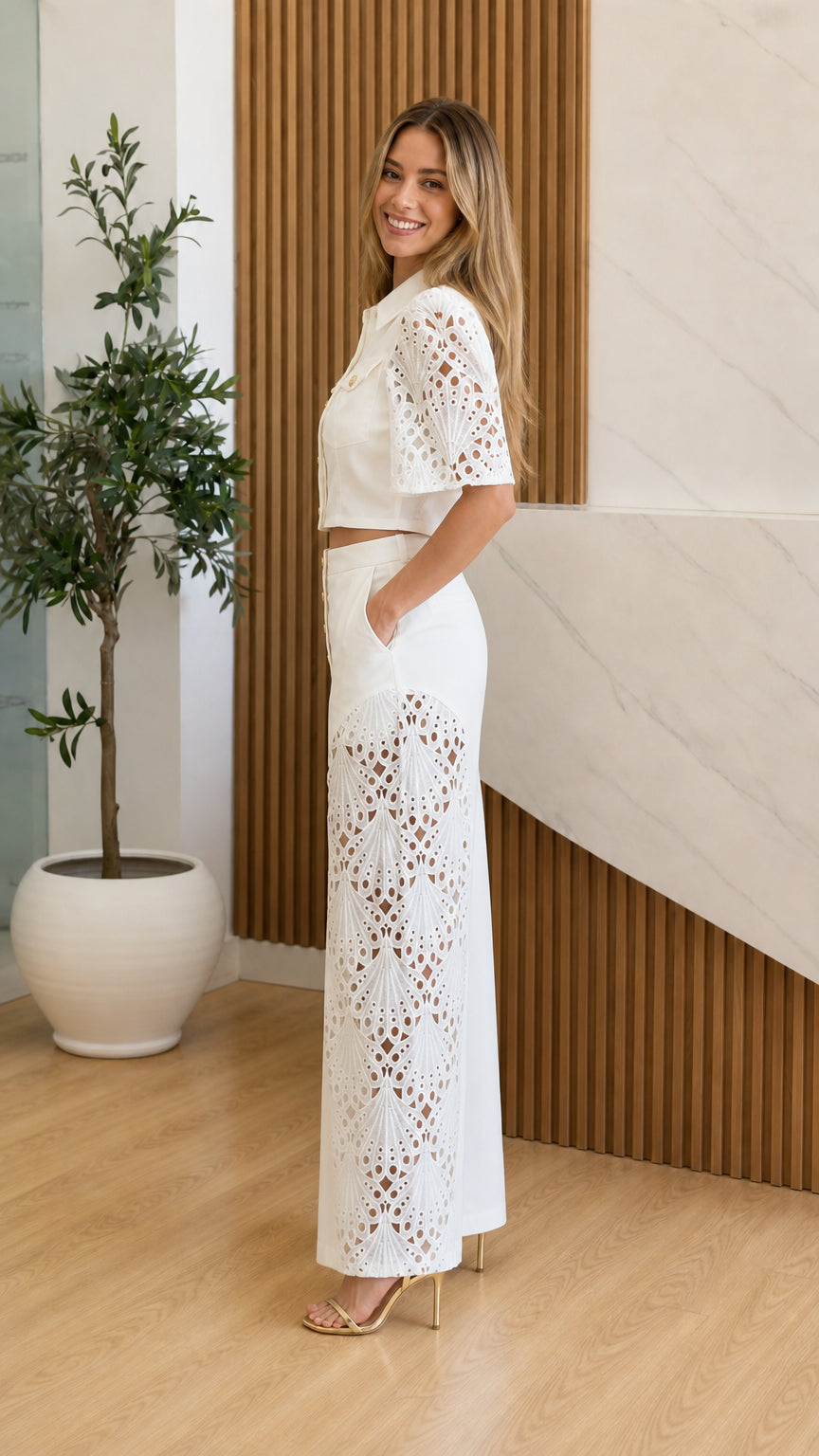 Side profile of model wearing white two-piece set with wide leg cutouts