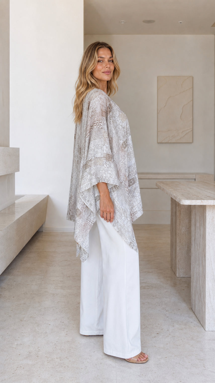 Model wearing beige printed boho poncho top side view