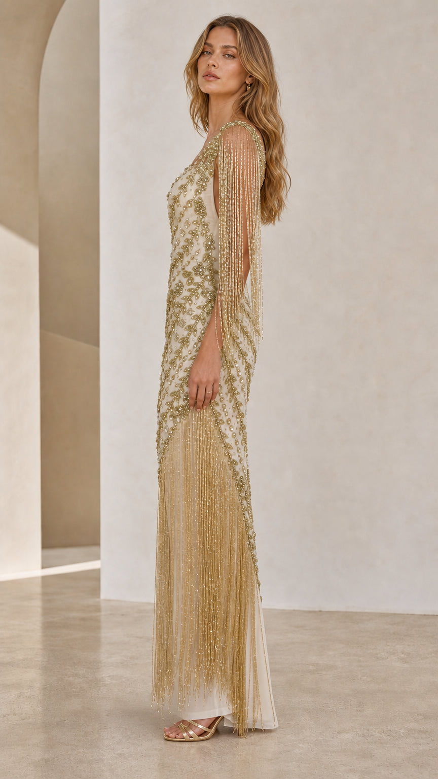 Side profile view of champagne beaded gown showing fringe detail