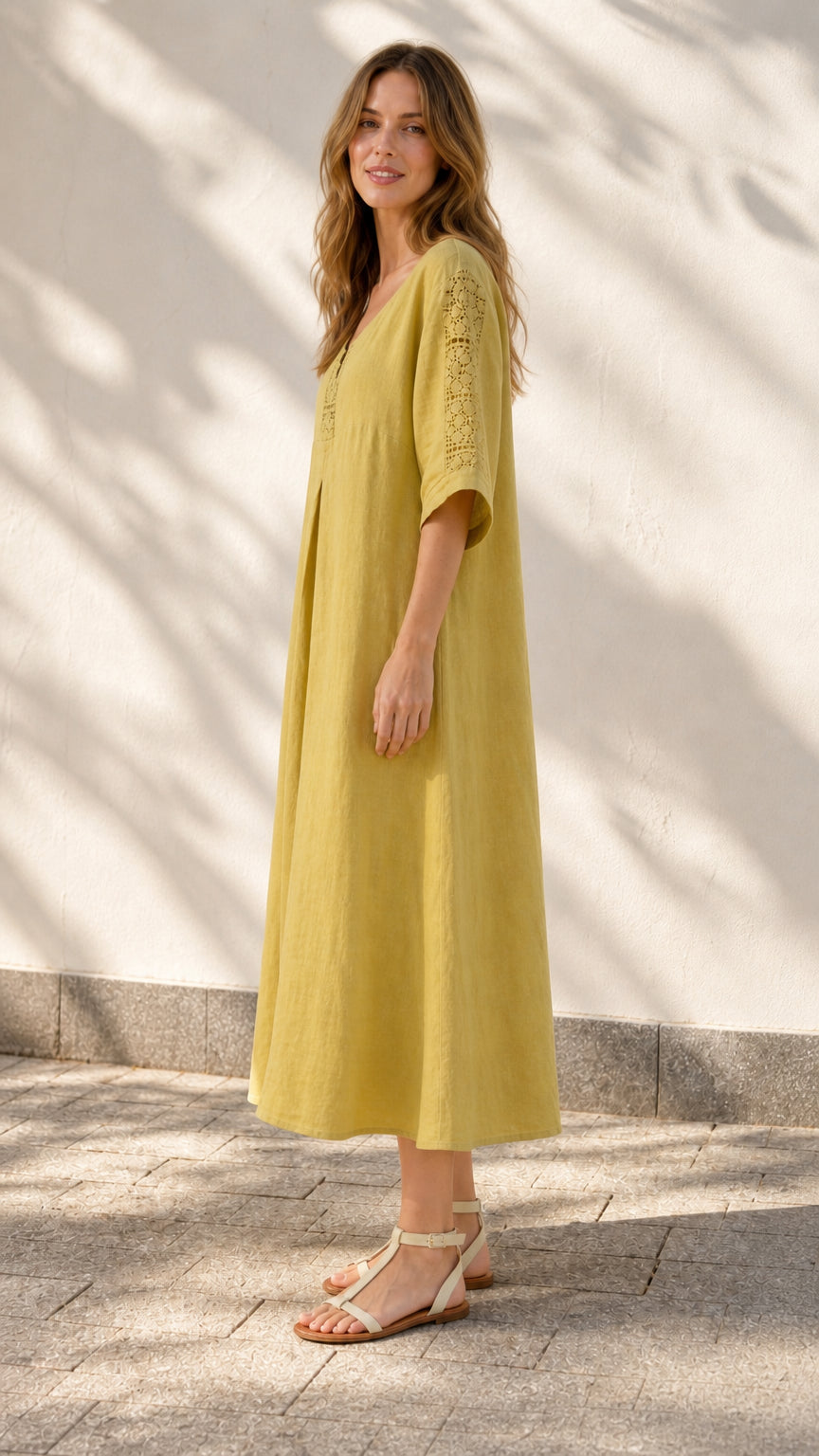 Side profile of model in yellow midi dress outdoors
