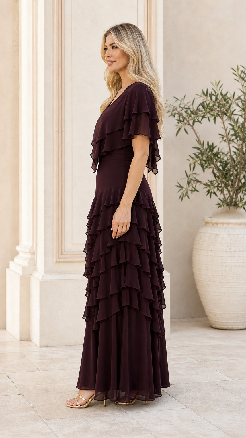 Side view of model wearing burgundy ruffle evening dress