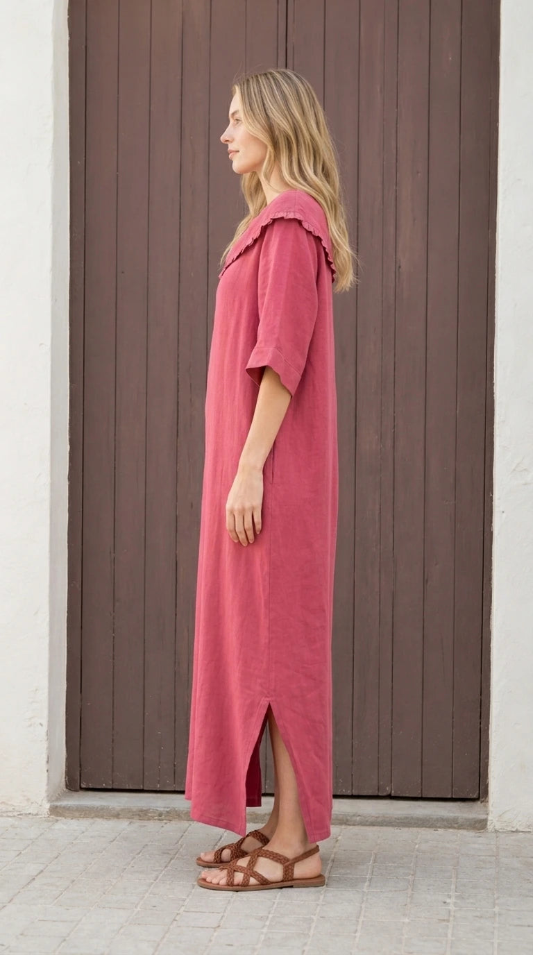 Side view of woman wearing rose pink maxi dress with side slit
