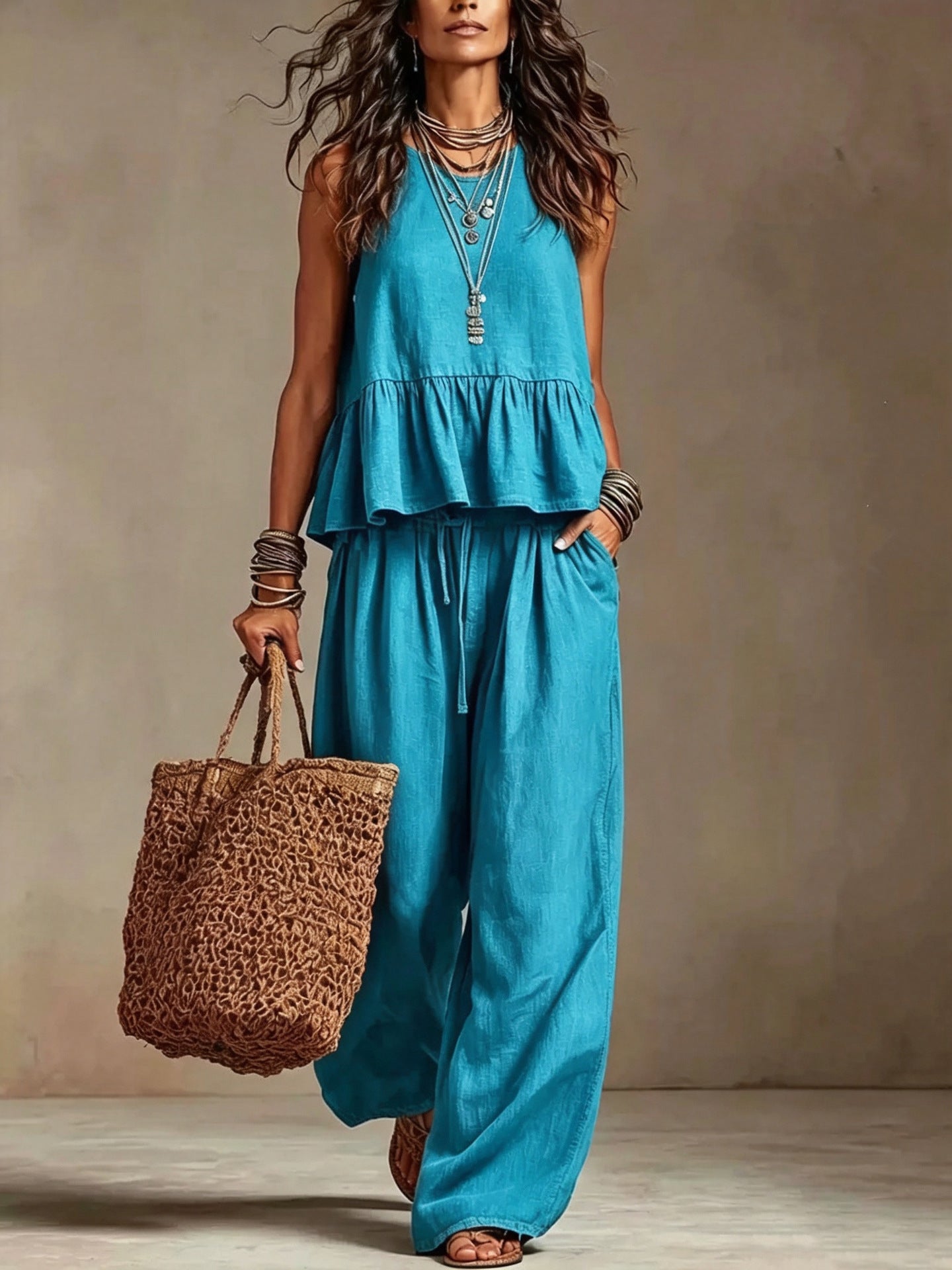 Woman wearing turquoise boho sleeveless peplum top and wide leg pants set