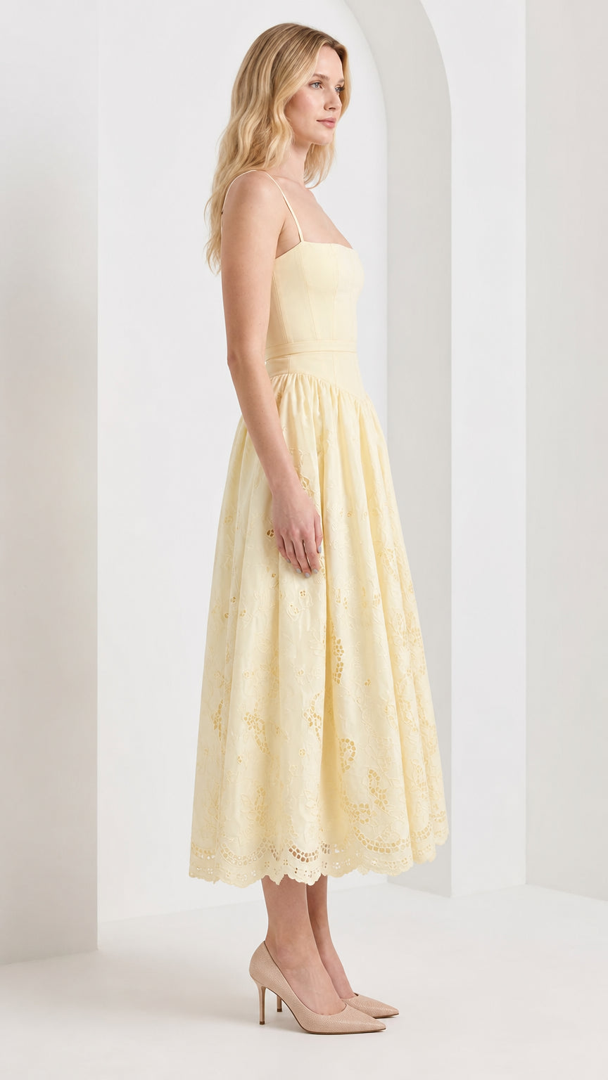 Side profile view of model wearing yellow midi dress with heels