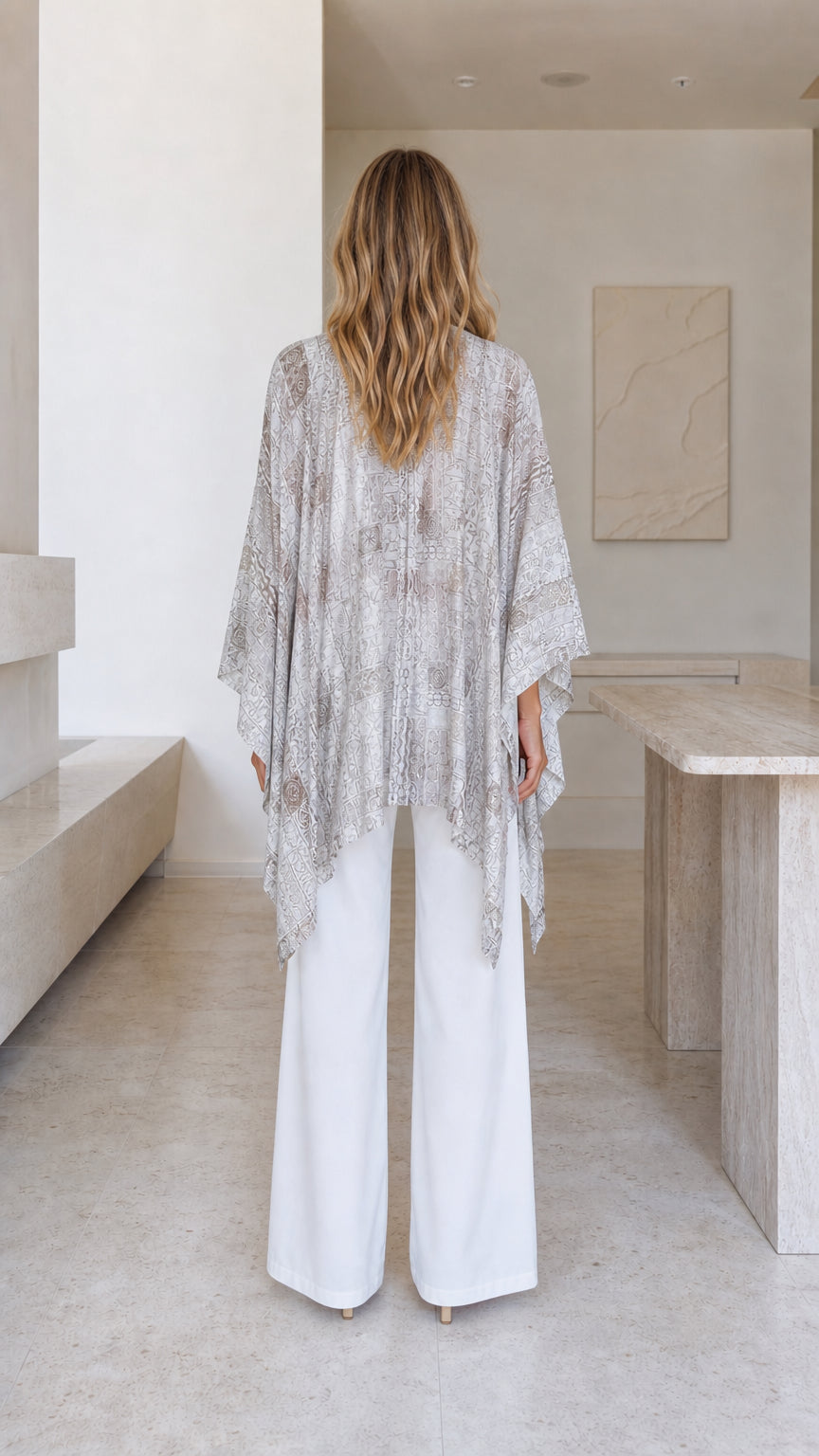 Model wearing beige printed boho poncho top back view