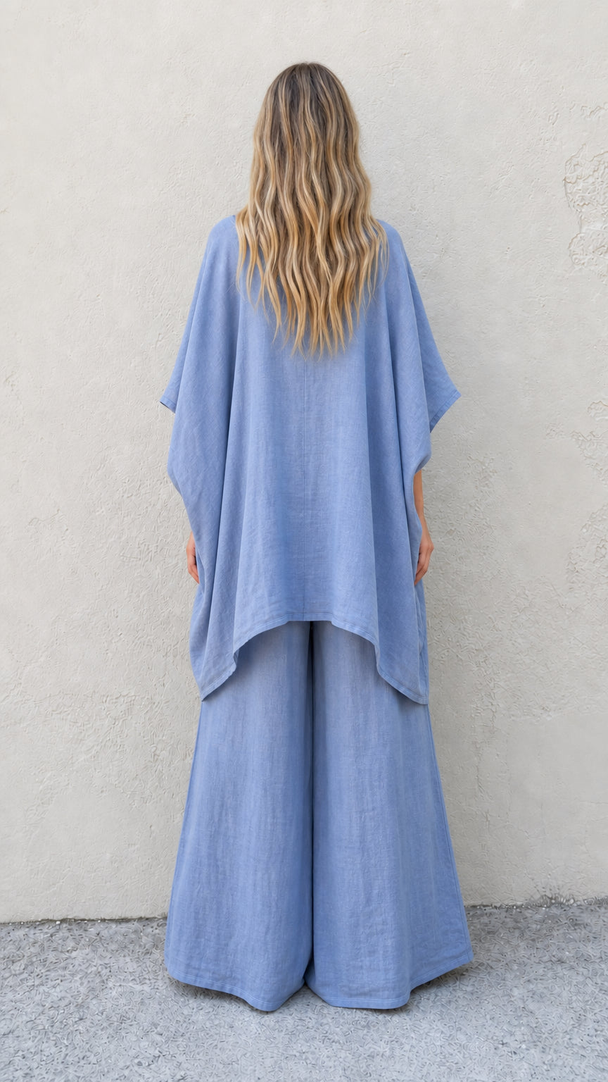 Back view of woman wearing blue poncho and trousers set