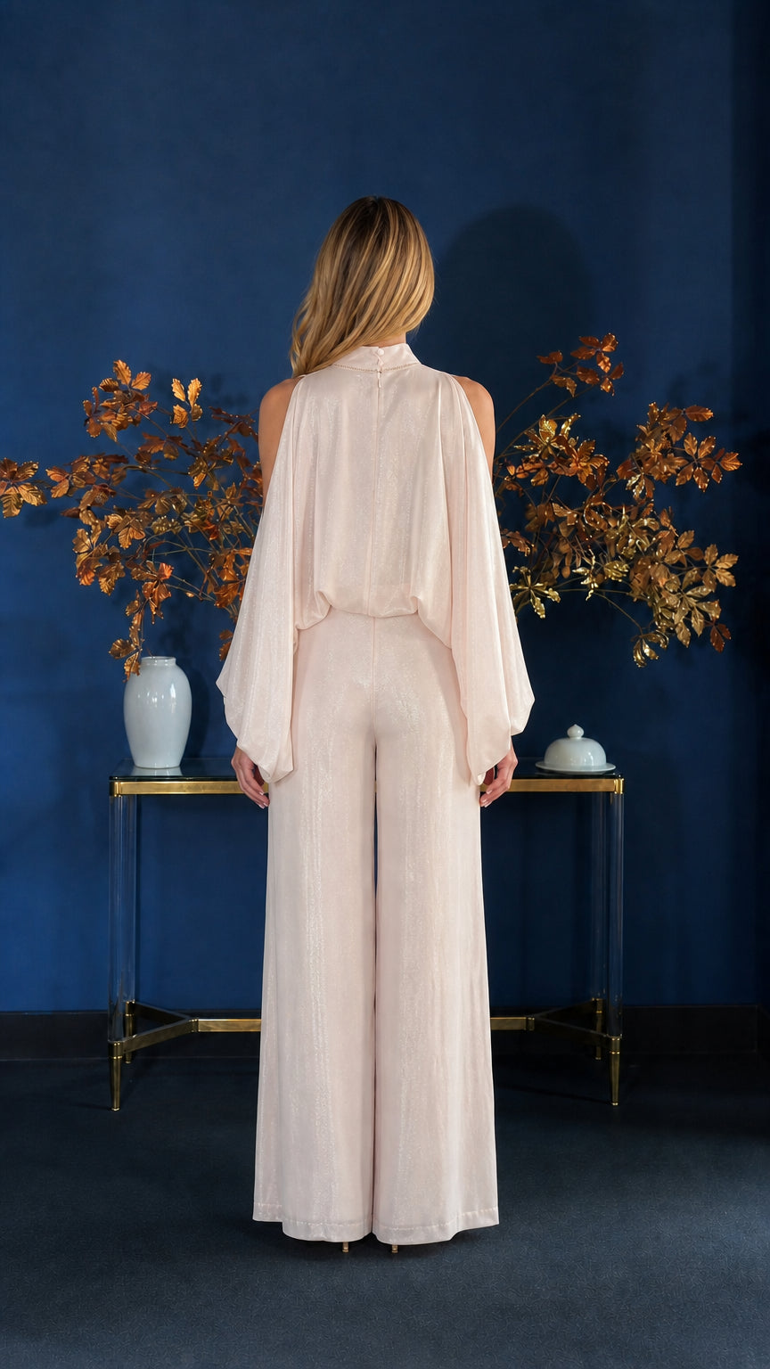 Back view of champagne jumpsuit with cape overlay