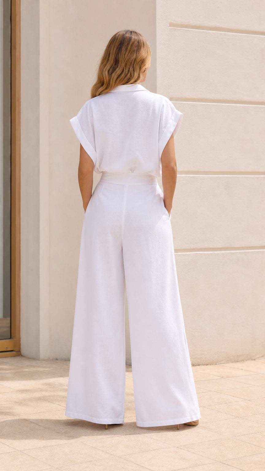 Back view of woman wearing white jumpsuit