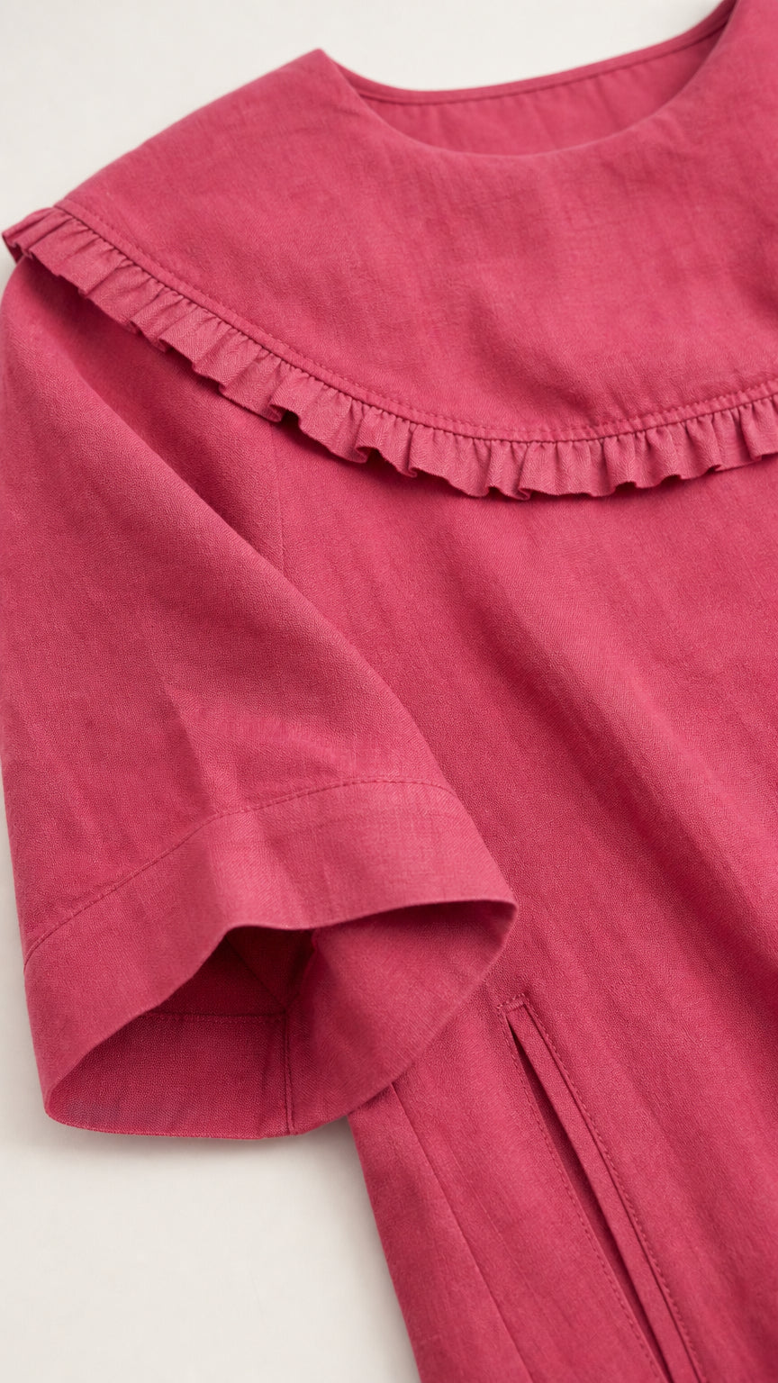 Close up of ruffled sailor collar and sleeve on rose pink dress