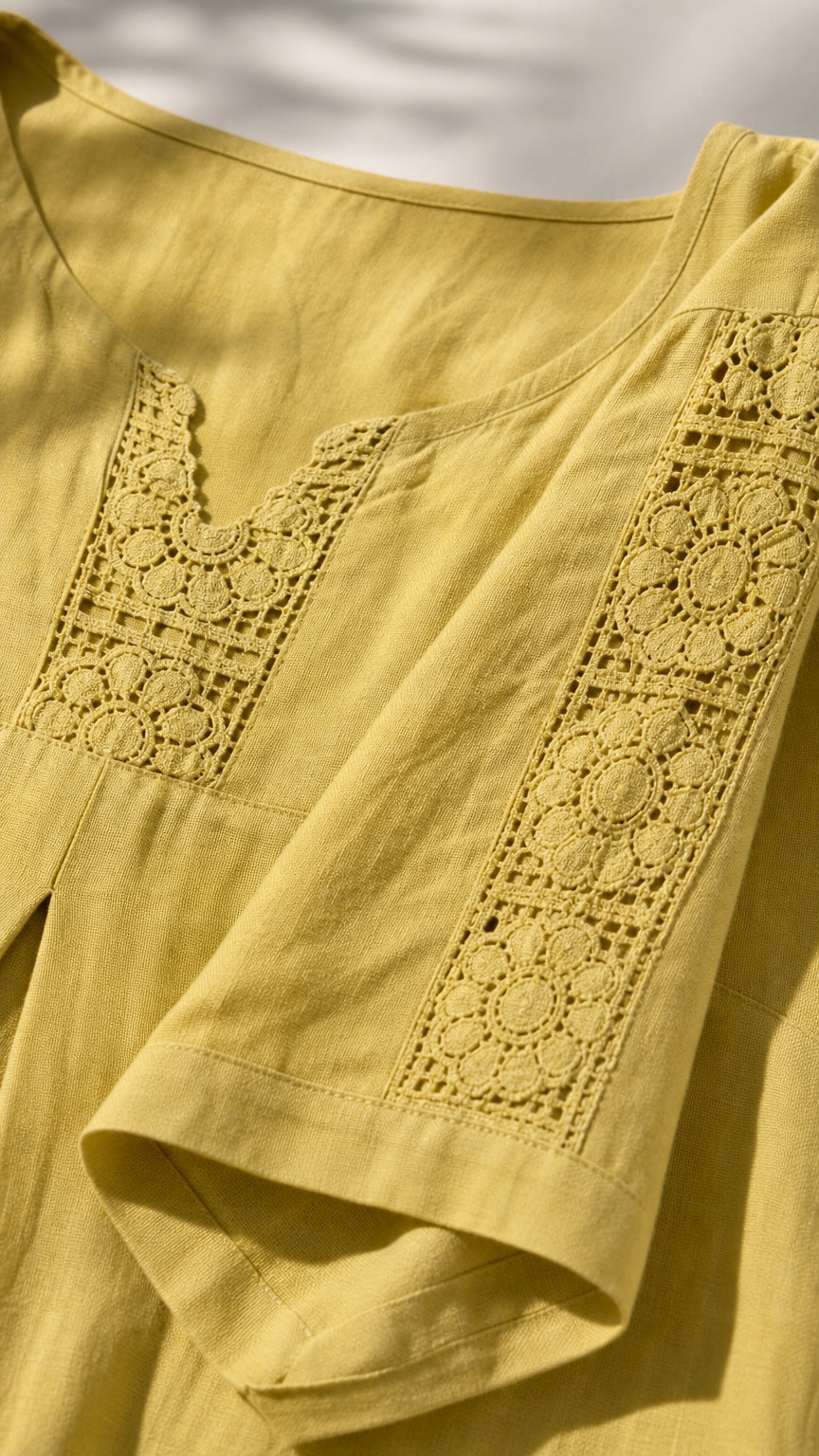Close-up of crochet lace neckline and sleeve detail on yellow dress