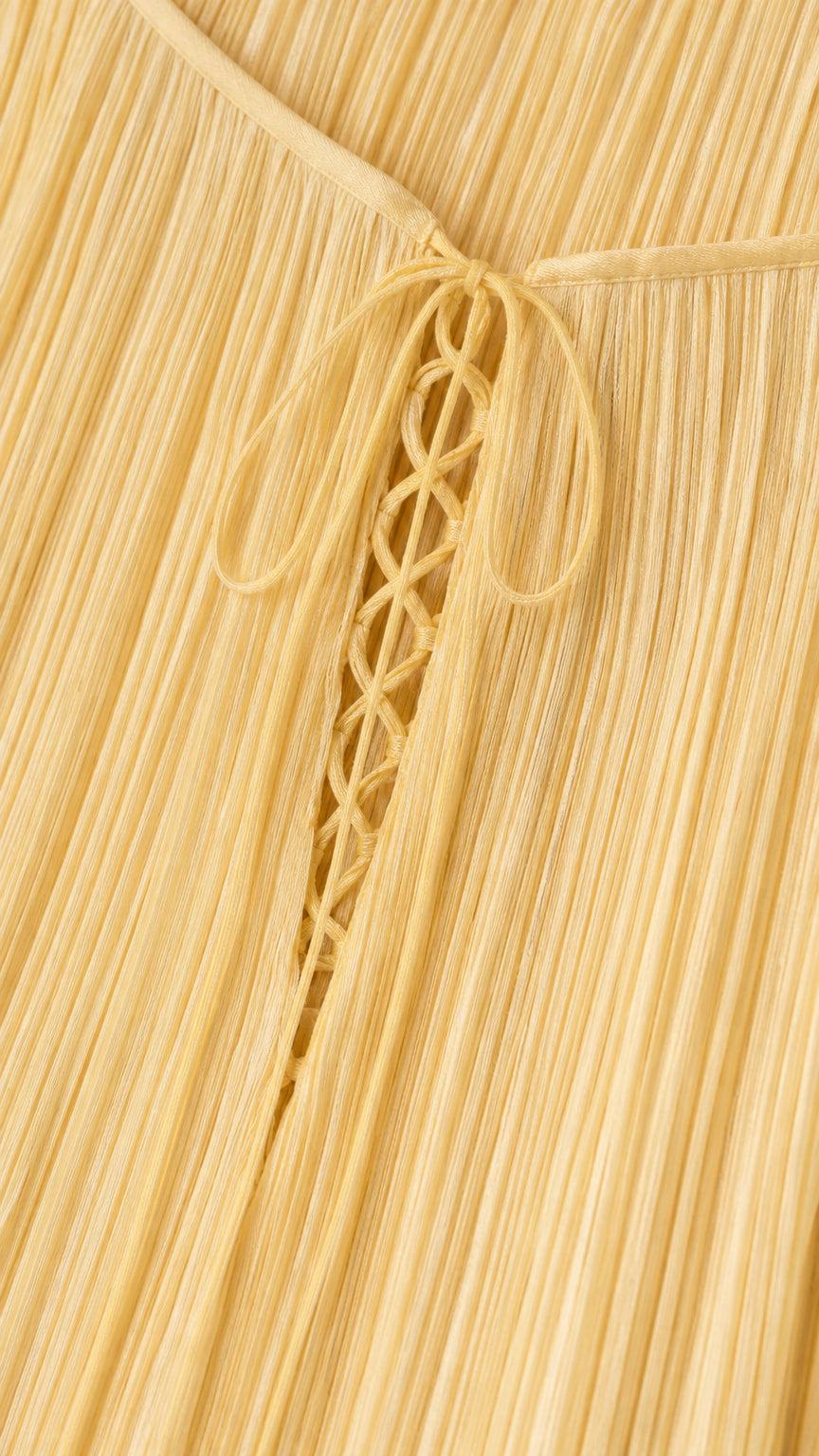Close-up of back lace-up detailing and yellow pleated fabric