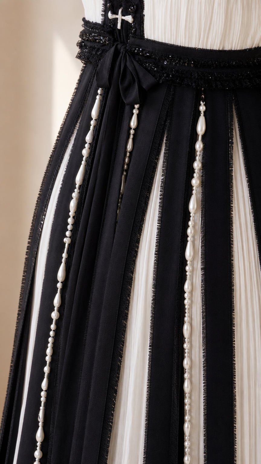 Close-up detail of ribbon and pearl beadwork embellishments