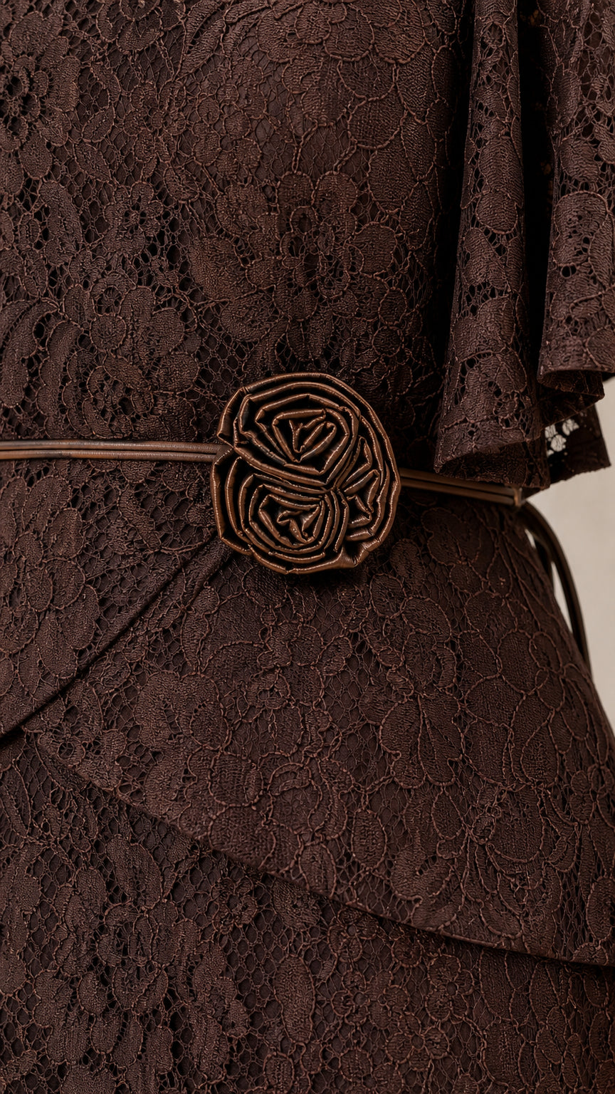 Close-up of waist rosette belt on brown lace dress