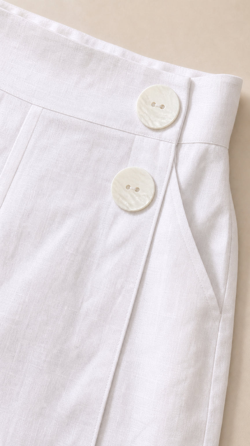 Close-up of white jumpsuit high waist detail with buttons