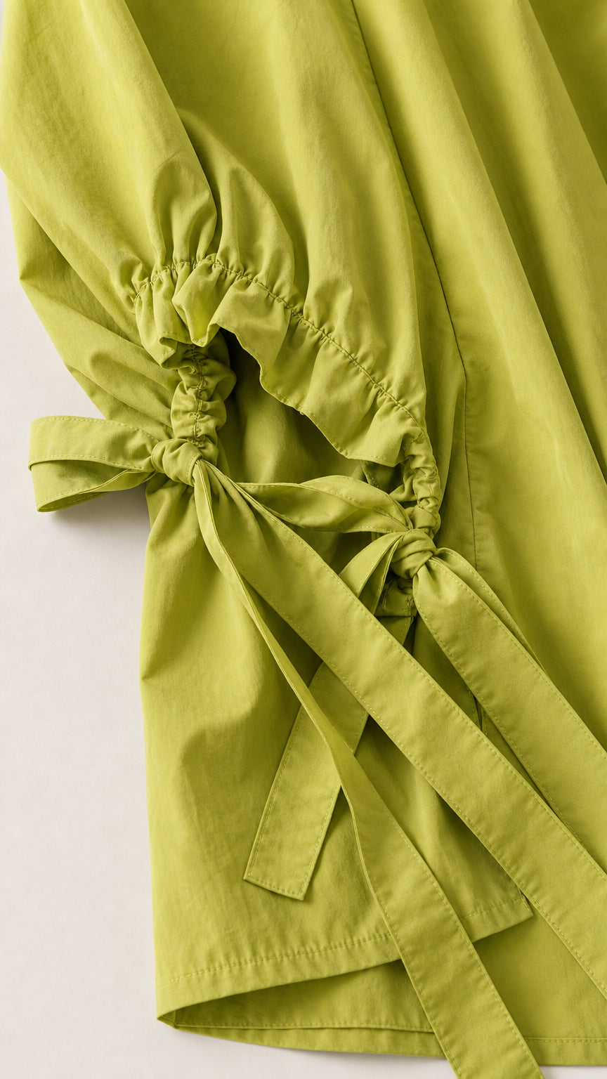Close-up of the gathered bow-tie sleeve detail on lime green top