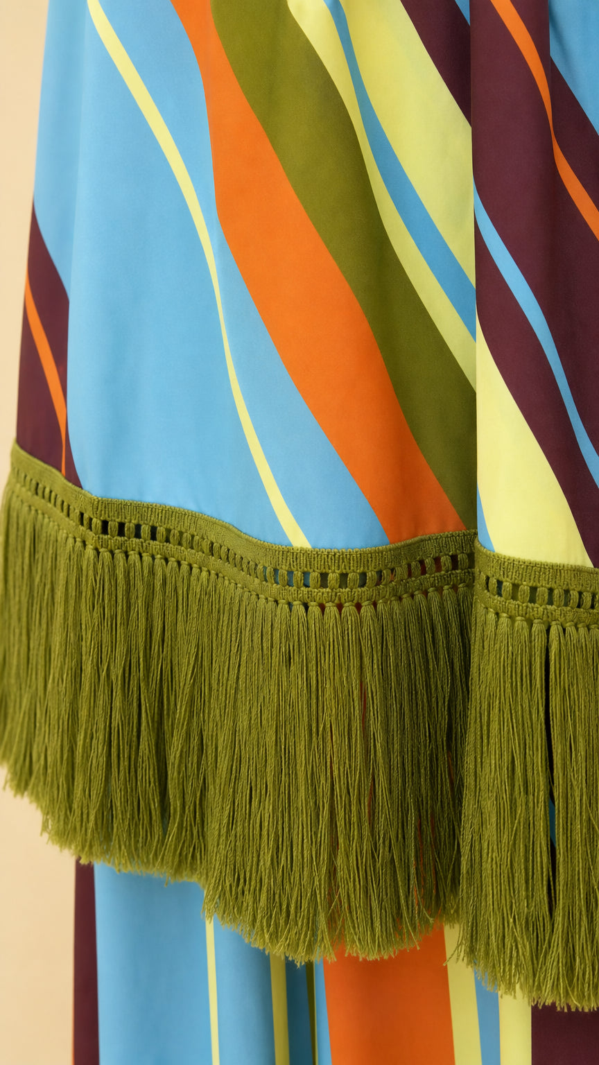 Close-up detail of the green fringe trim and striped fabric