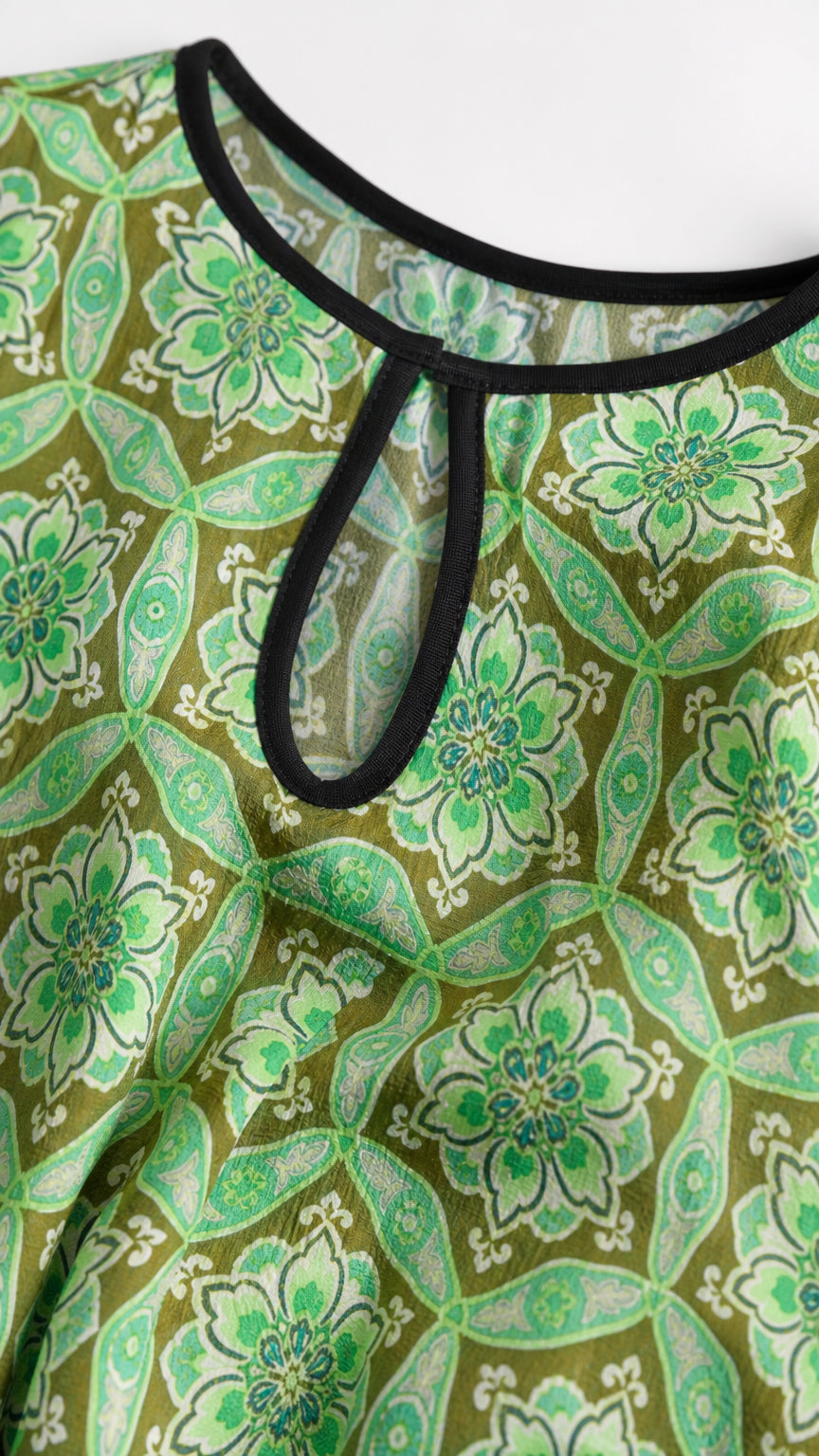 Close up of keyhole neckline and green floral fabric detail