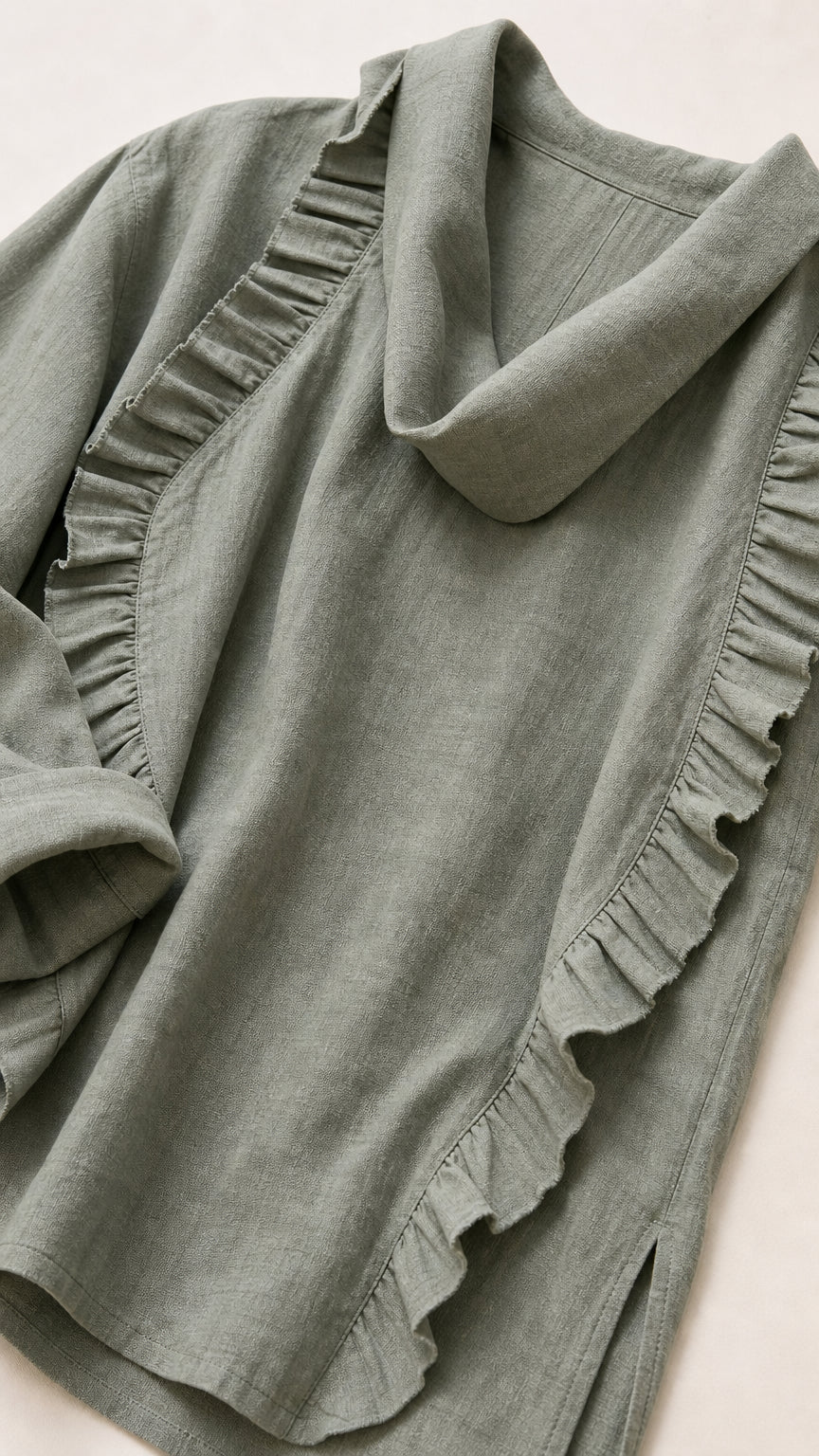 Close-up detail of sage green fabric, cowl neck, and ruffles