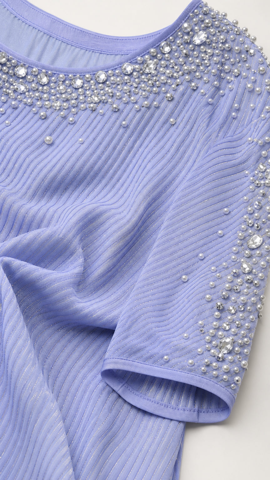 Close-up of rhinestone and pearl beadwork on collar and sleeve