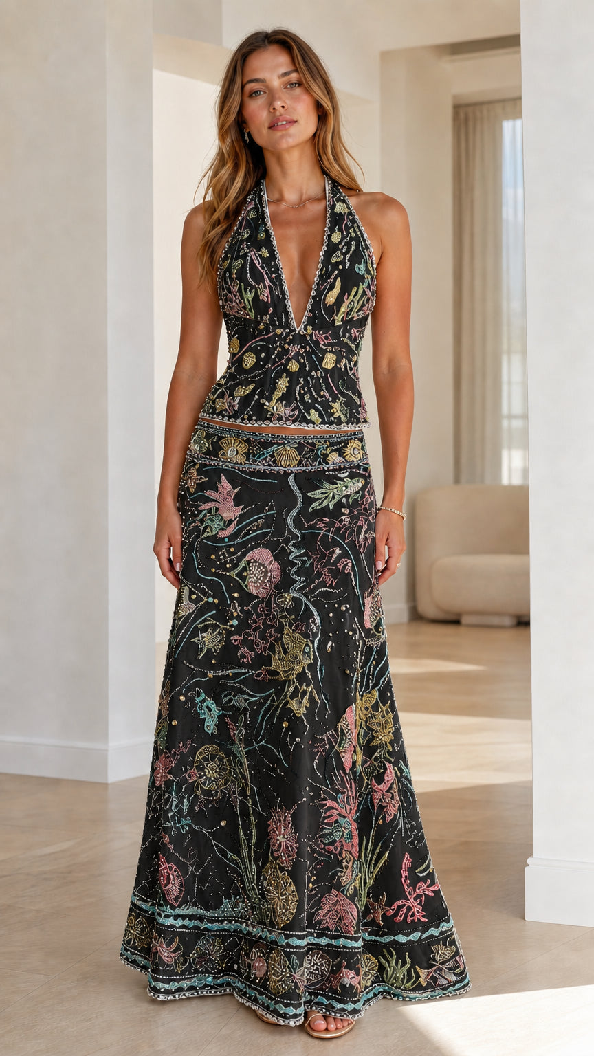 Woman wearing black embroidered halter crop top and maxi skirt set