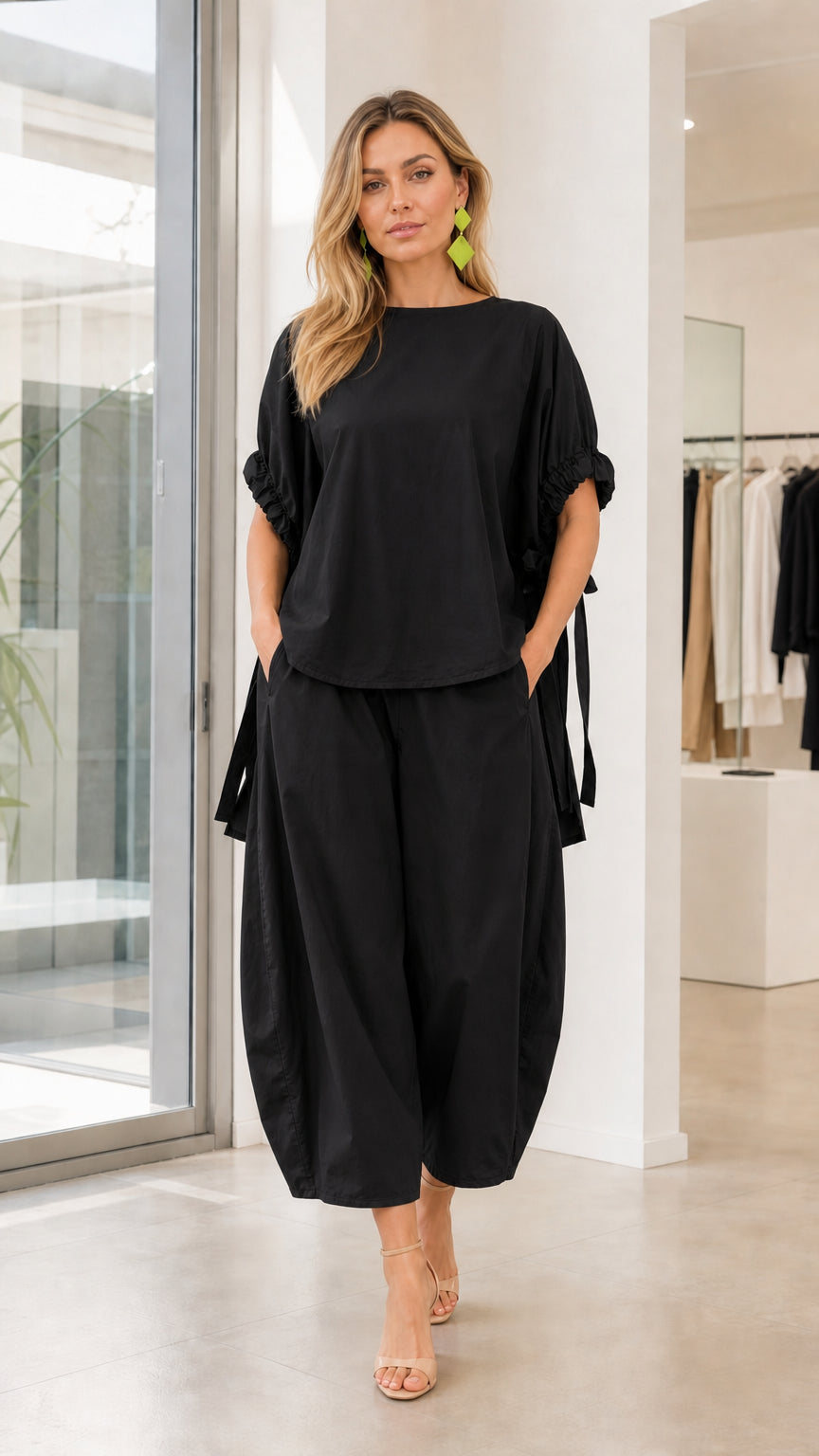 Model wearing black two-piece lantern pants set