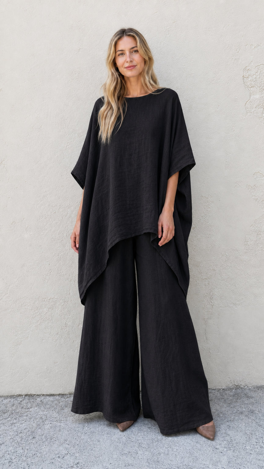Woman wearing black two-piece poncho and wide leg pants set