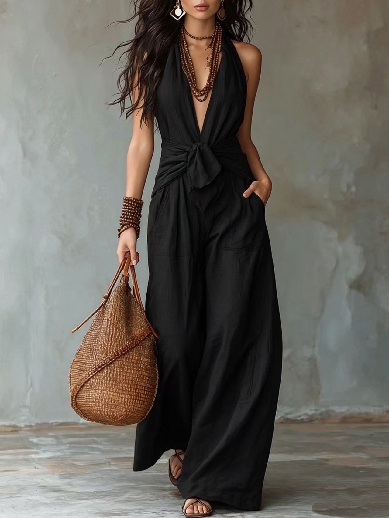 Model wearing black halter tie waist wide leg jumpsuit