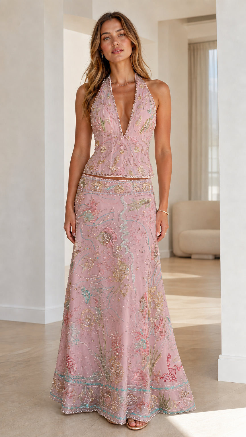 Woman wearing pink embroidered halter crop top and maxi skirt set