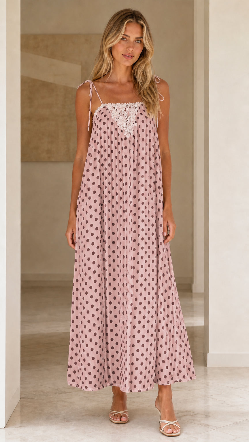 Front view of woman wearing pink polka dot maxi dress