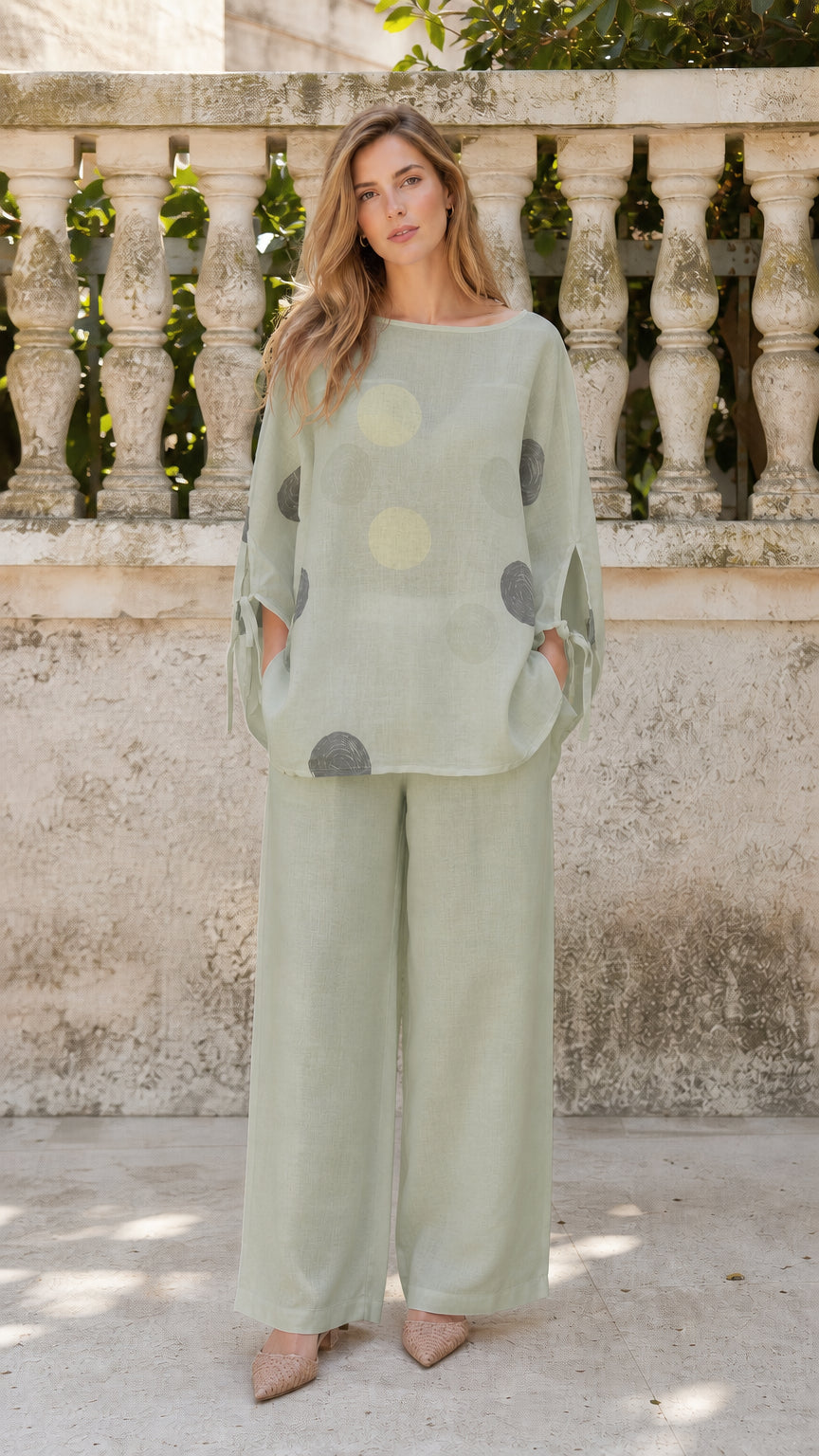 Front view of woman wearing sage green polka dot two-piece set