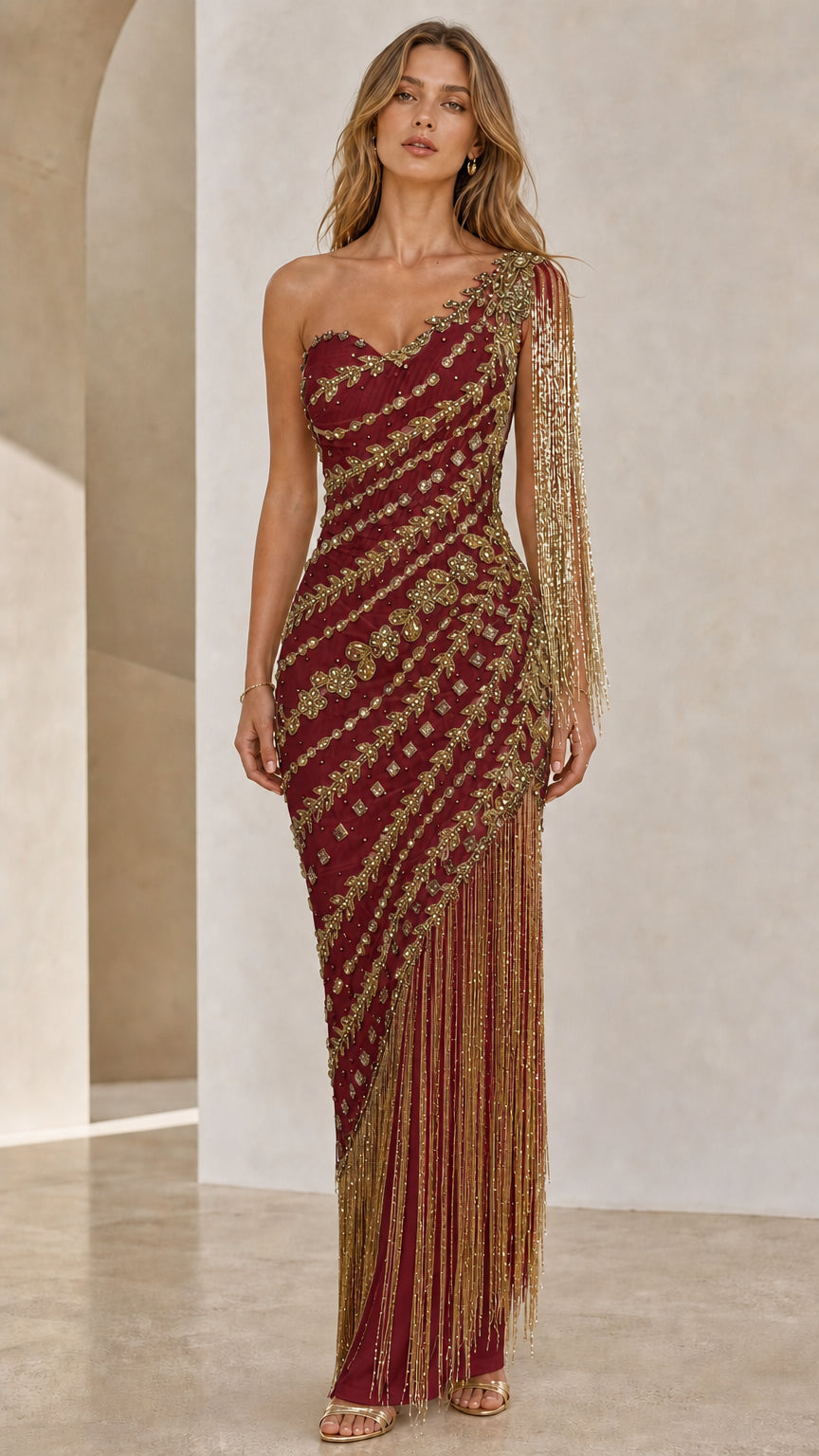Front view of model wearing burgundy one-shoulder beaded fringe gown
