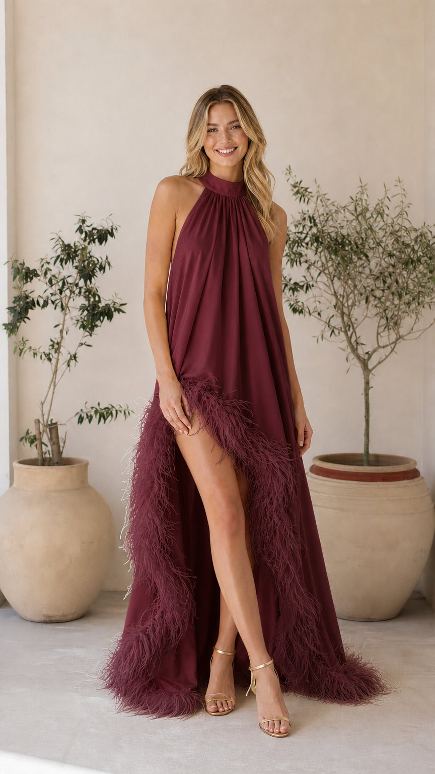 Model wearing burgundy feather trim halter maxi dress