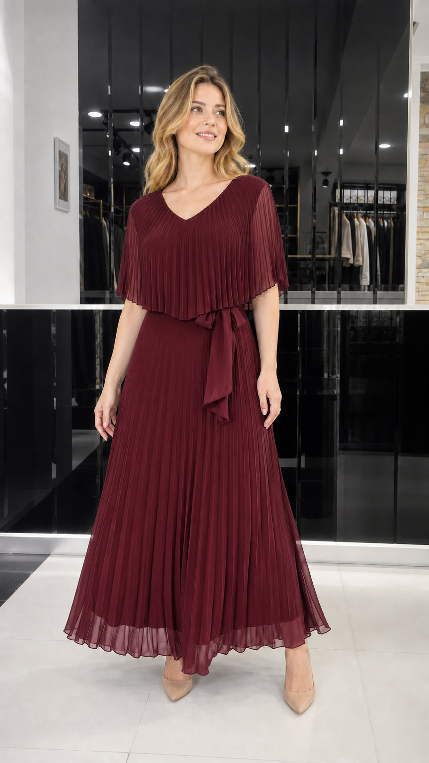Model wearing burgundy pleated cape overlay maxi dress