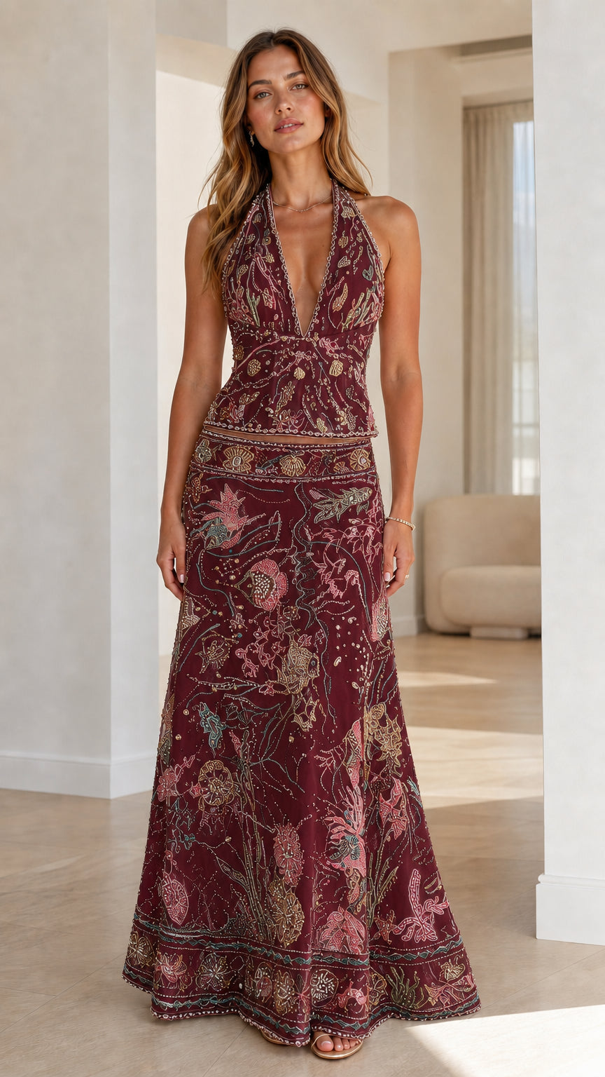 Woman wearing burgundy embroidered halter crop top and maxi skirt set